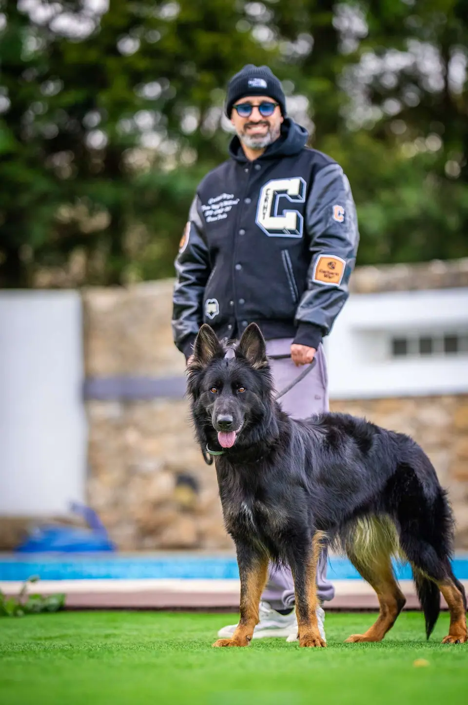 Treinador com um pastor-alemão à trela num espaço de treino